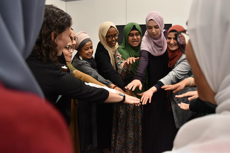 Photo of a program participants celebrating in a group circle