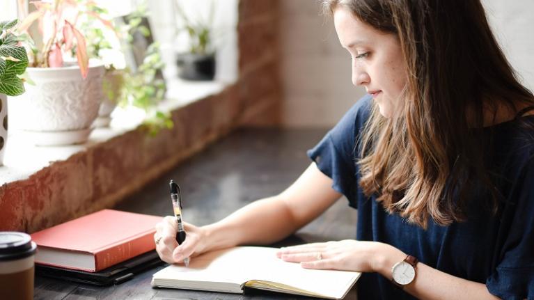 teenage girl writing in notebook