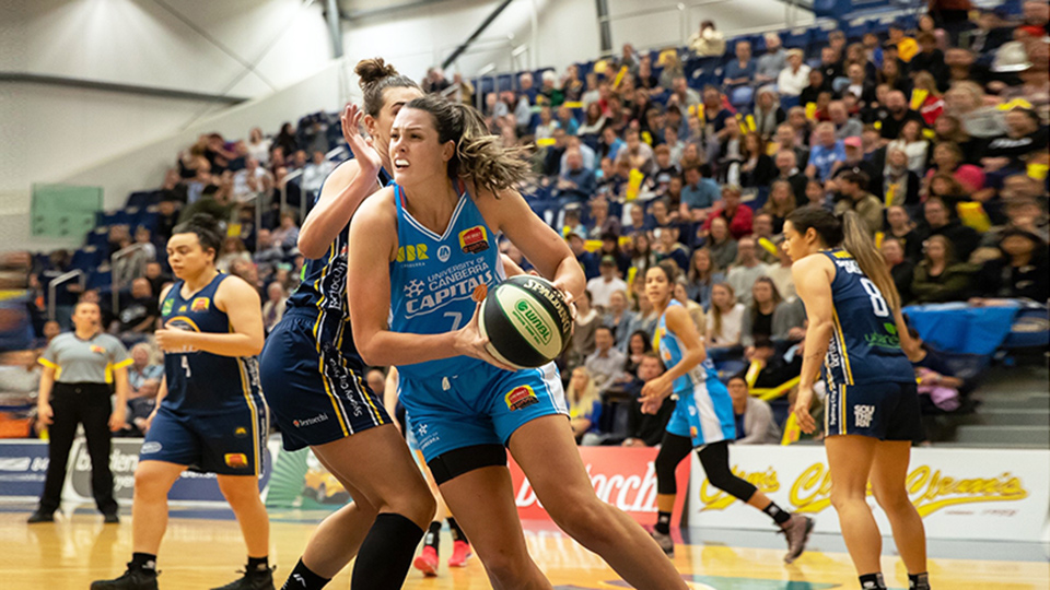 Lauren Scherf playing basketball with a crowd behind her