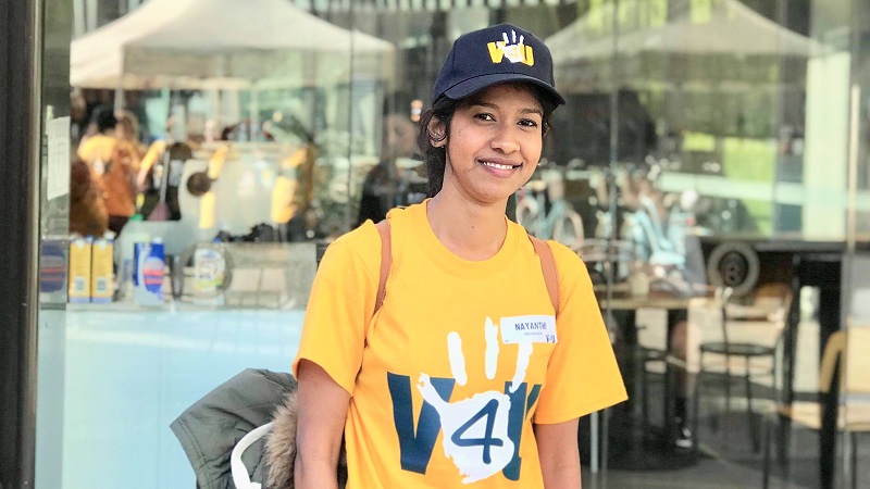 Nayanthi Jayawickrama, smiling, in a yellow V4U Vollies tshirt