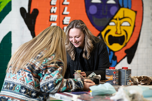 Chloe smiling, hands on at work helping a student