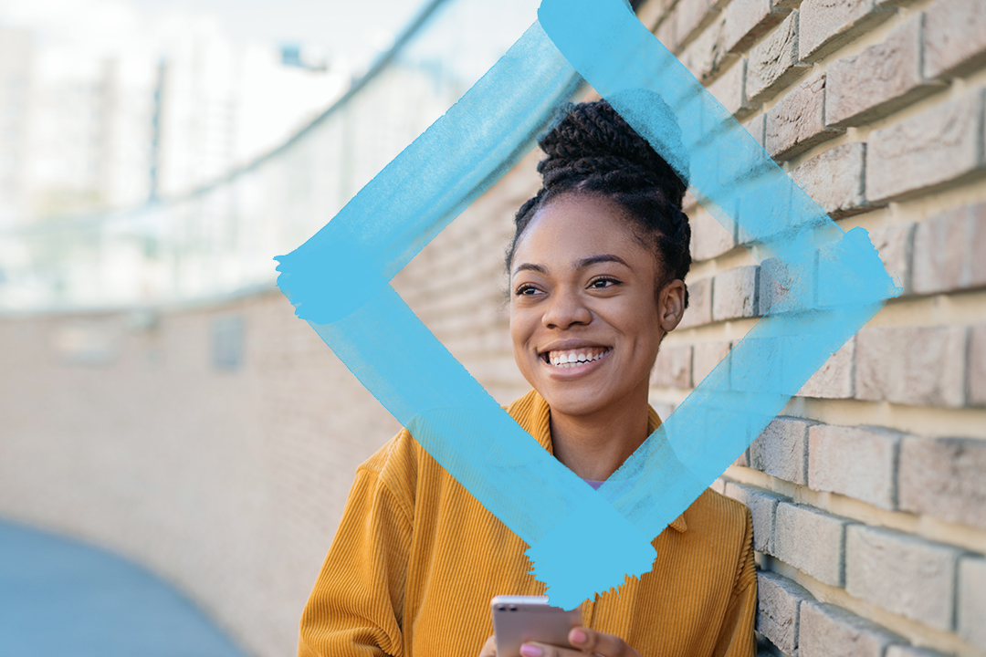 Student leaning against wall with VU blue branded diamond.