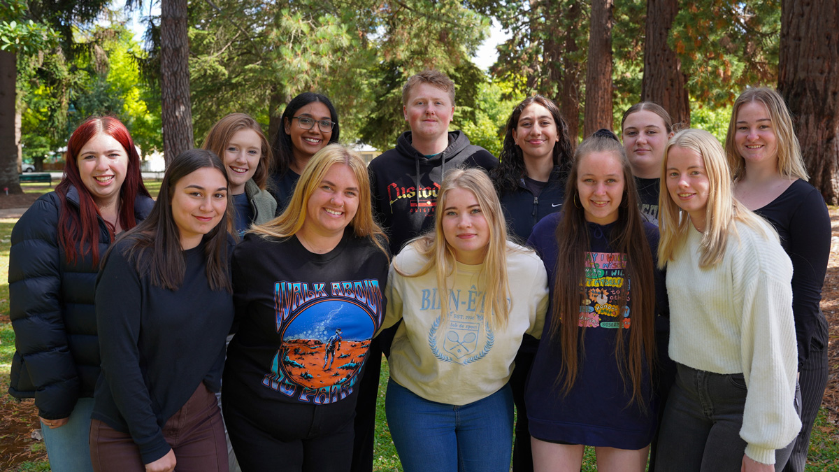 A group of students outdoors smiling at the camera