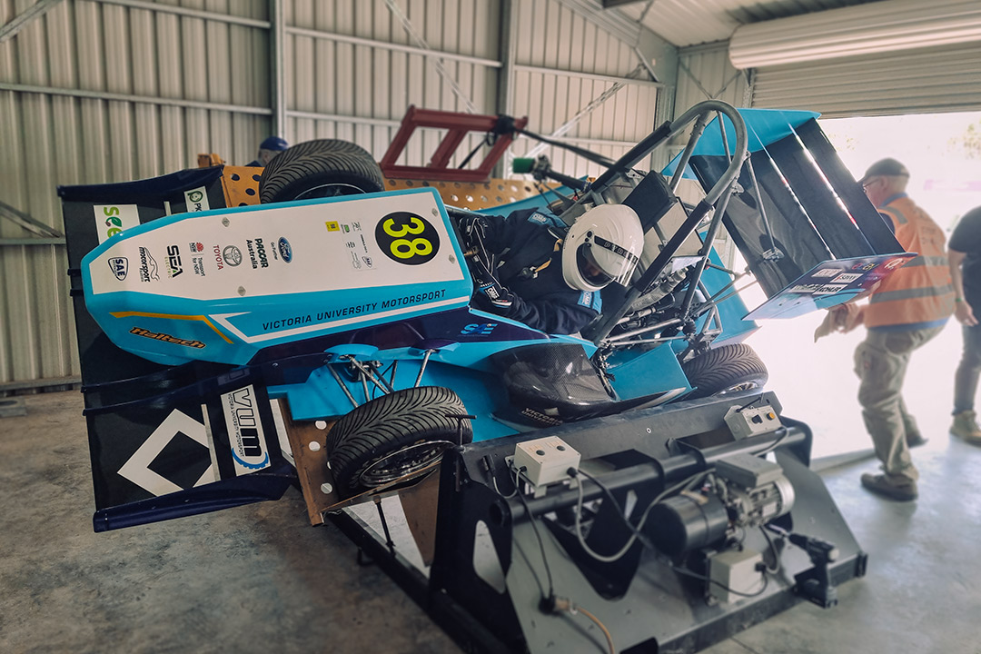 A blue & white racing car on a VU branded mechanical platform