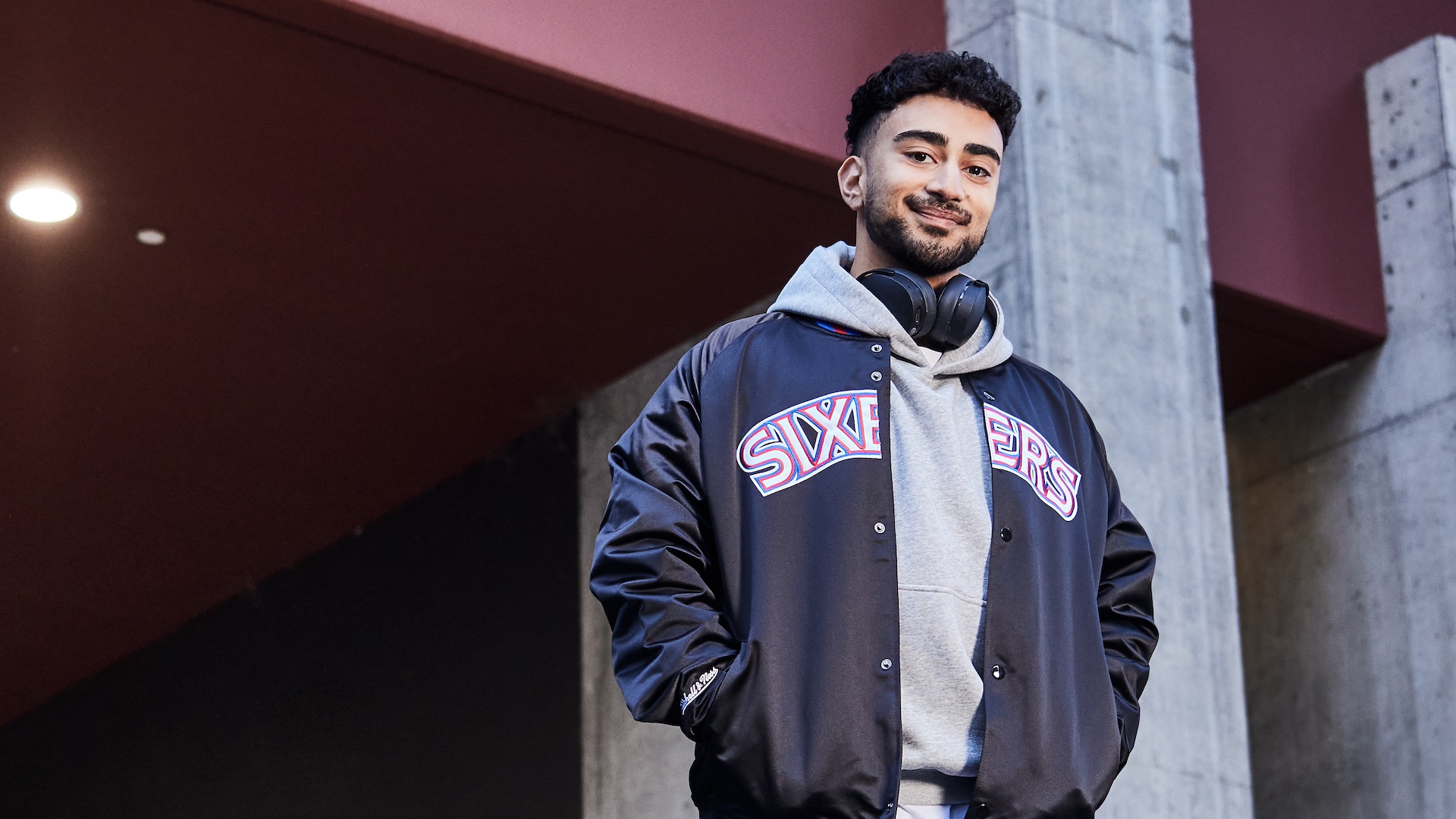 Mathew, wearing a hoodie and jacket, stands confidently with headphones around his neck. He is quoted explaining how VU gave him a pathway to his dream course.