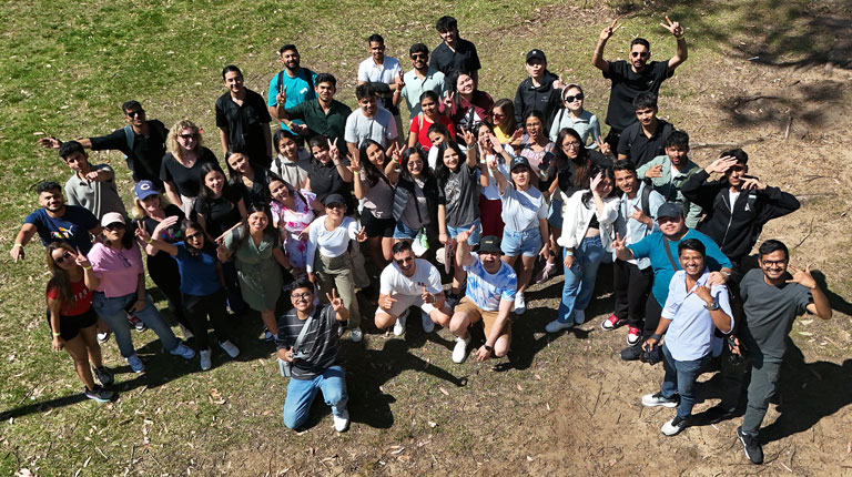 A large group of students standing outside and posing for the camera.