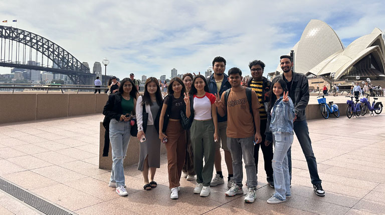 A group of VU Sydney students standing outside the Sydney Opera House