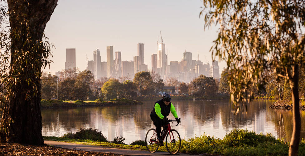 Cyclist along the Maribynong River with City skyline in backgound