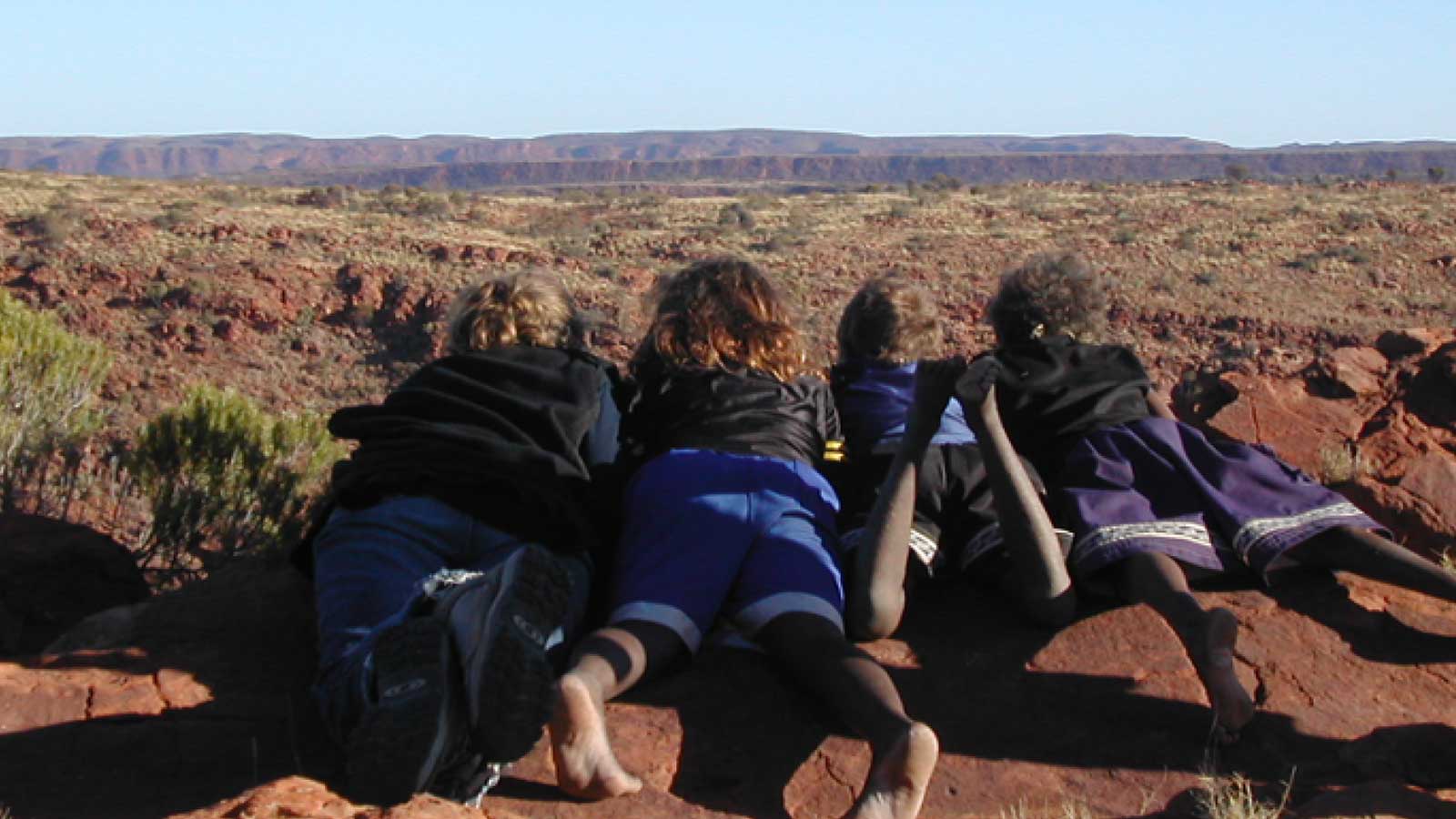 SWiRL school students lying on the ground looking into the distant landscape