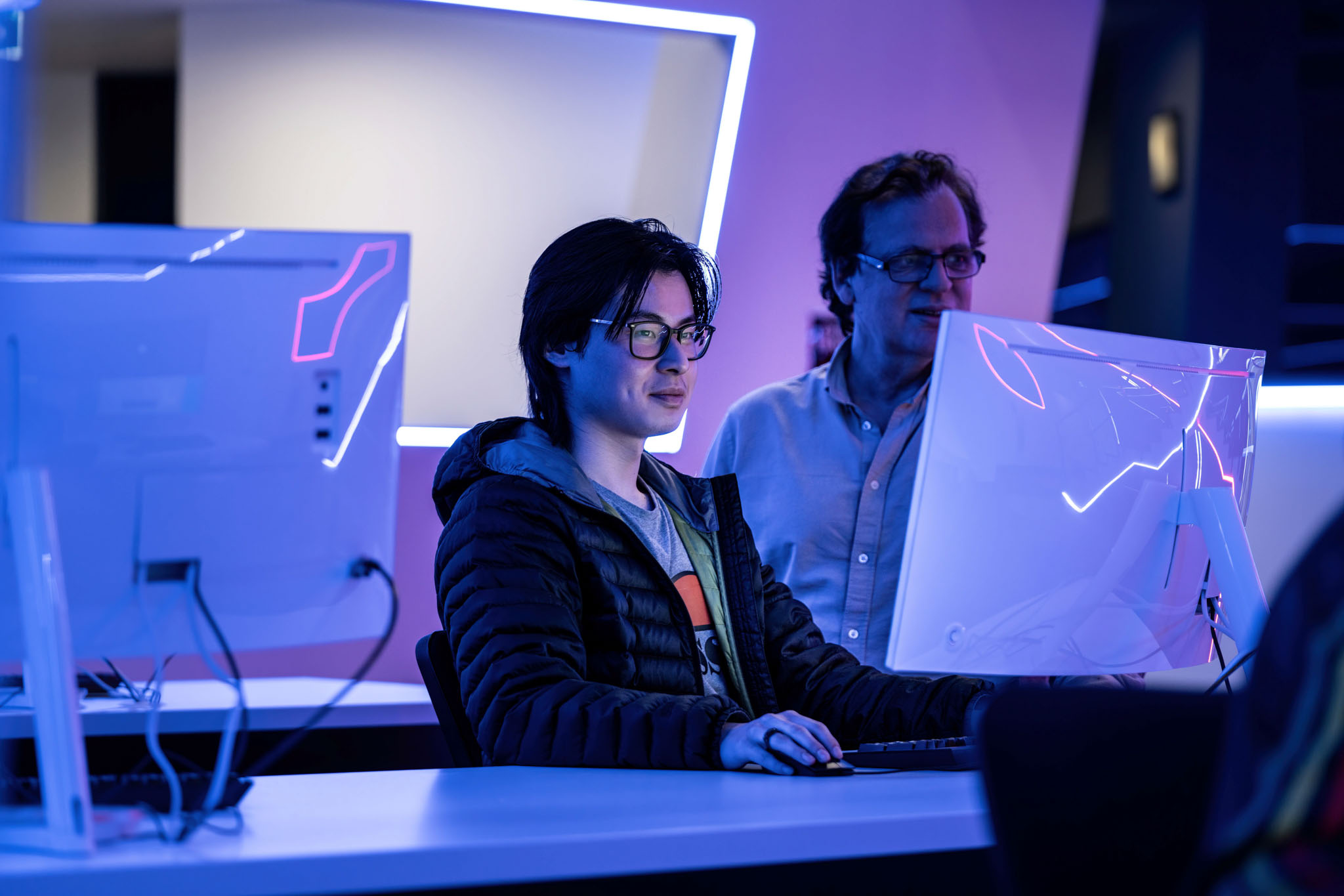 two international students looking at laptop and working in a lab