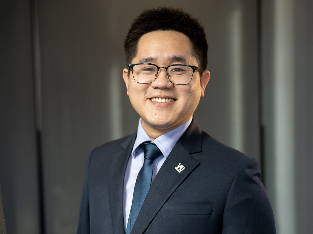 A young man in a suit poses for the camera
