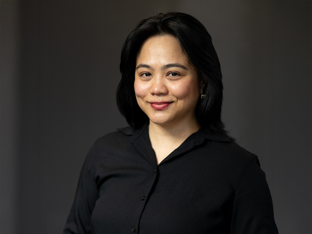 A woman poses for a photo in a neat black shirt