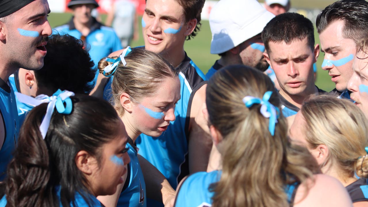 VU Vultures team members in a huddle, talking amongst each other.