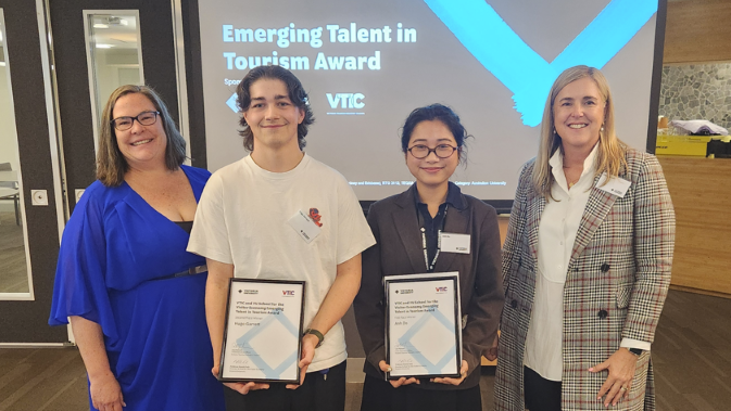 Two young award recipients pose with staff holding certificates