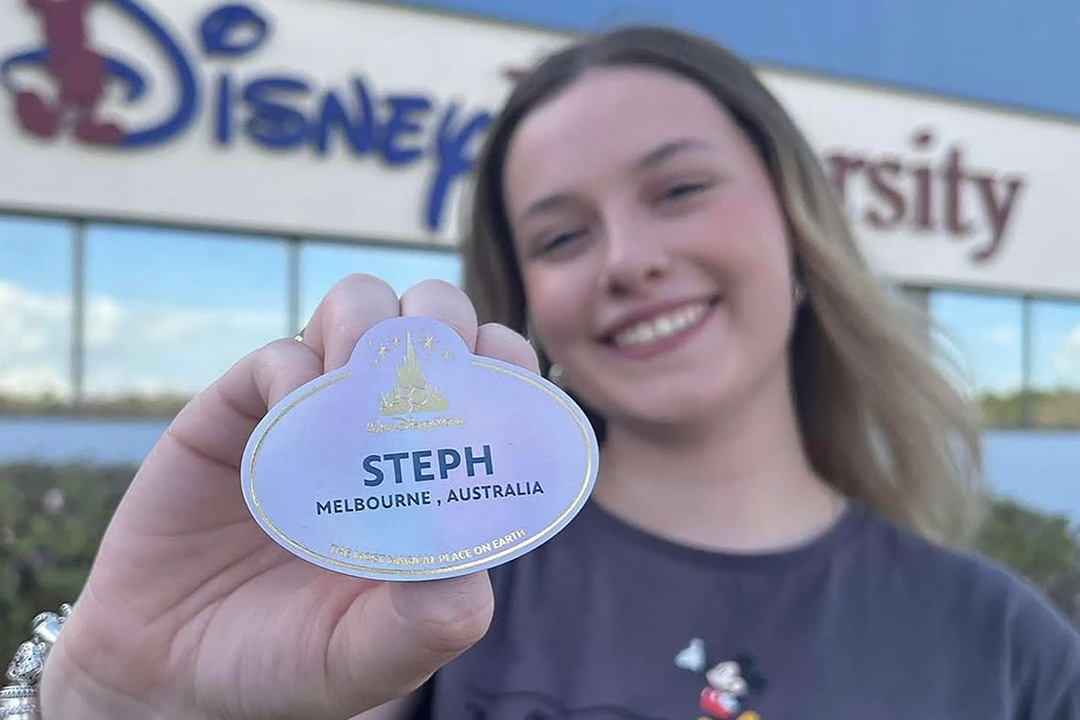 VU Graduate Steph holding up her Disney name badge at her WIL placement