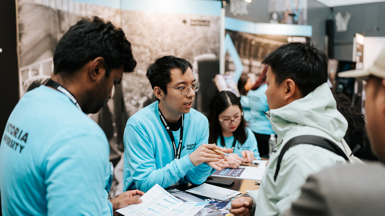 A VU staff member talking to a future student about a study area