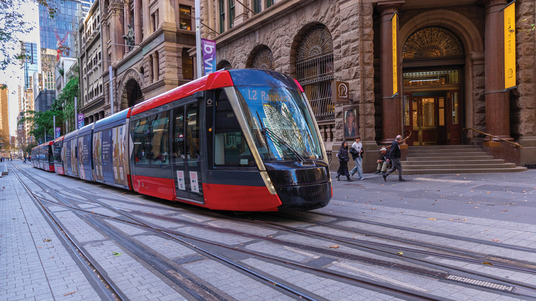A modern red tram on an elegant city street