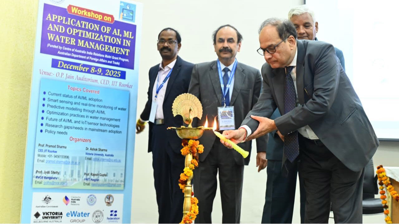 A group of people standing next to a standing poster. One person is lighting the lamp.