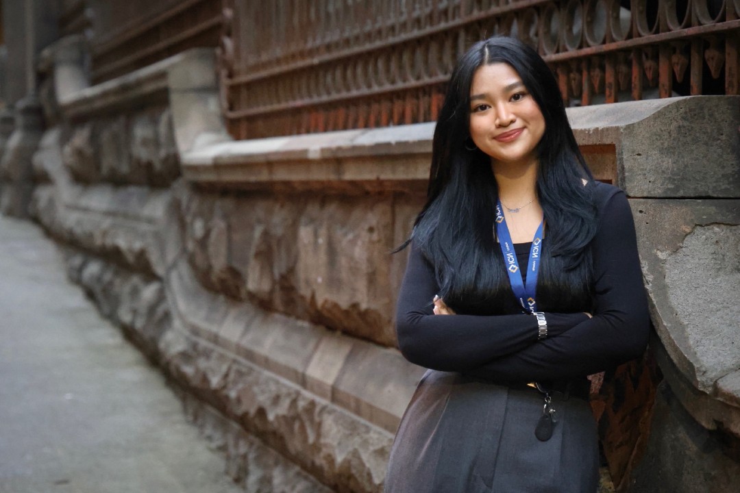 VU Student Samantha Espiritu leaning against a stone bridge