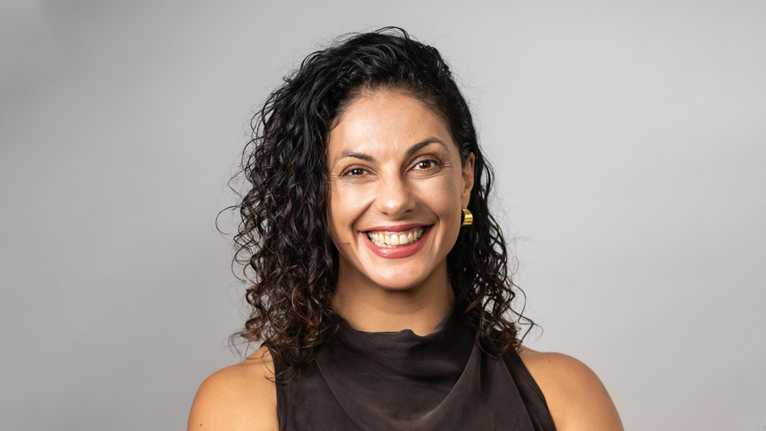 Headshot of woman smiling directly at camera.