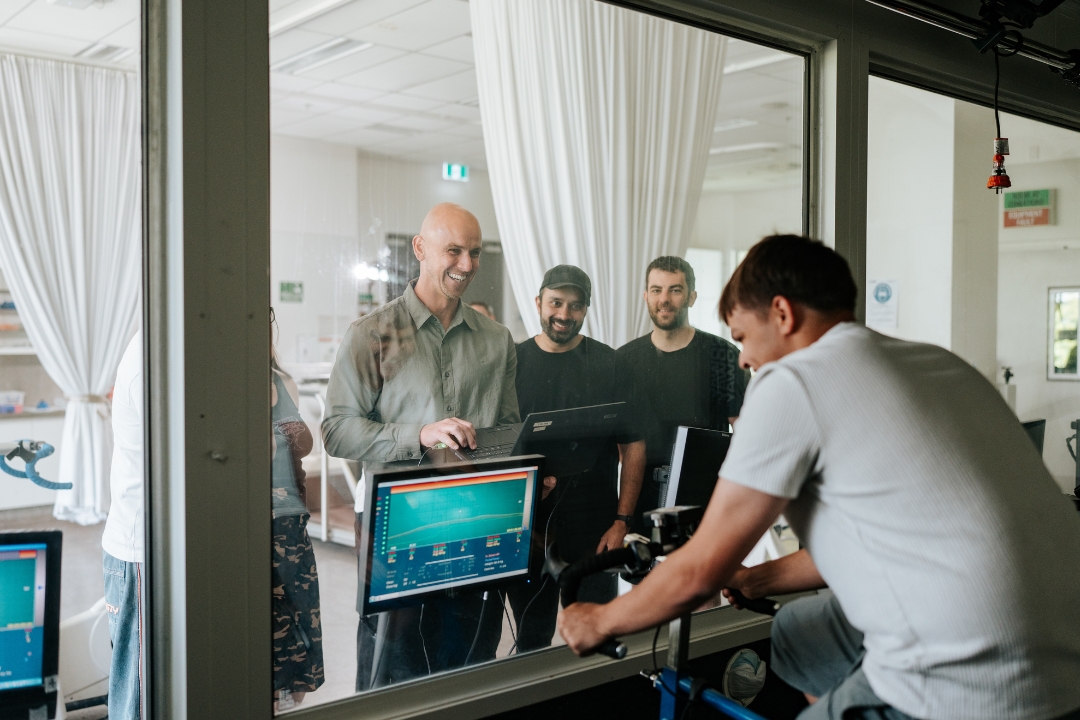 Research participant on stationary bike in environmental chamber