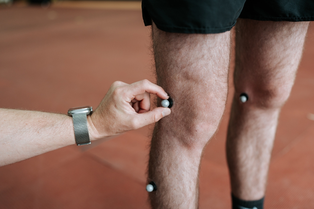 Person attaching motion sensors to another person's leg