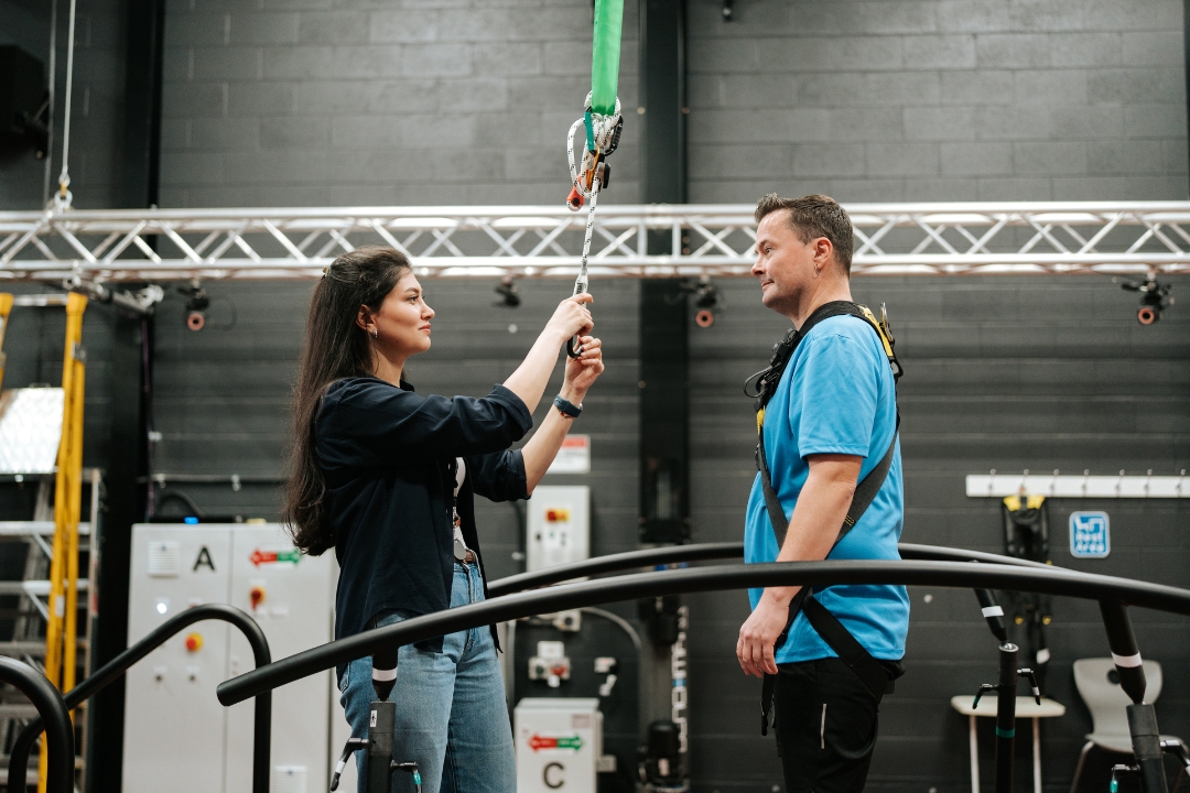 Researcher strapping participant to treadmill