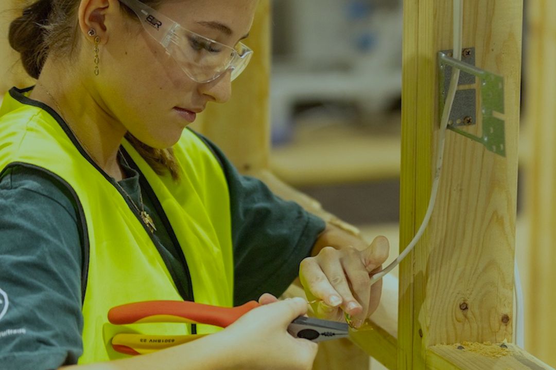 Electrotechnology student rewiring house frame