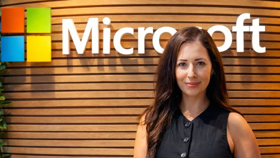 A woman standing in front of a wall with a Microsoft sign