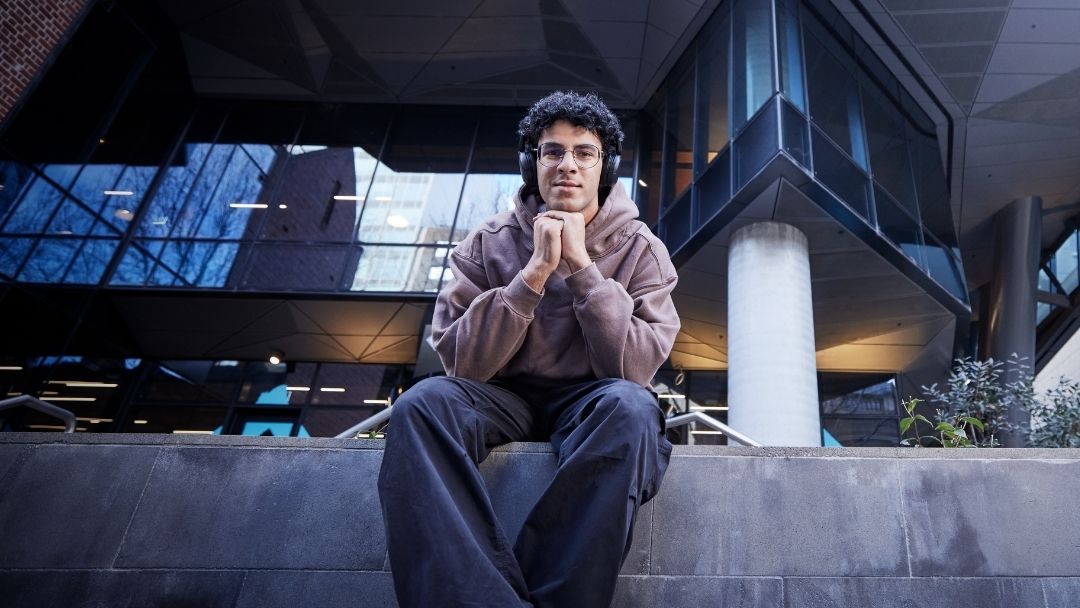 Student sitting outside VU City Tower