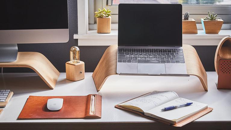 A desk with a study plan sitting by a mouse, in front of a laptop.