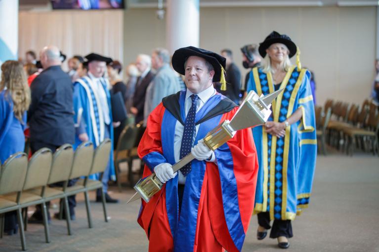 Academic carrying the University Mace