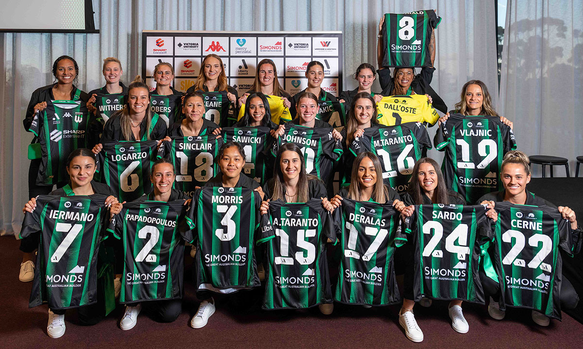 Women's football team proudly hold up team jerseys