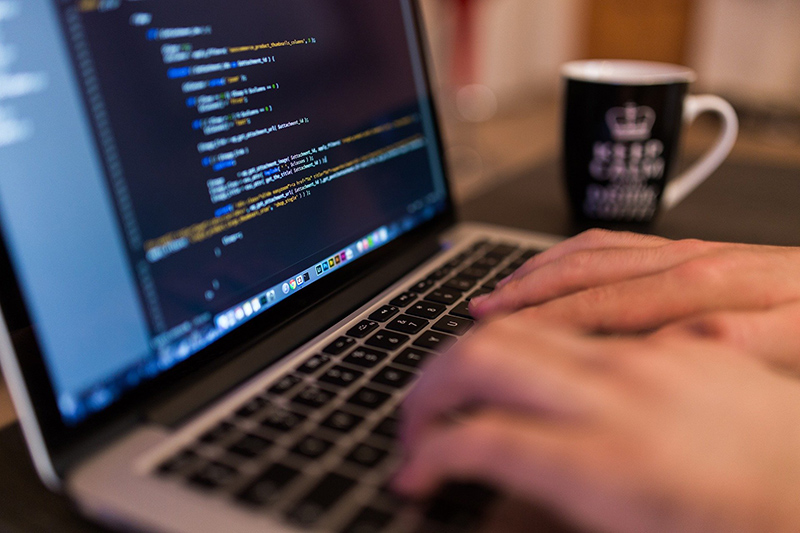 hands typing -- computer screen with code
