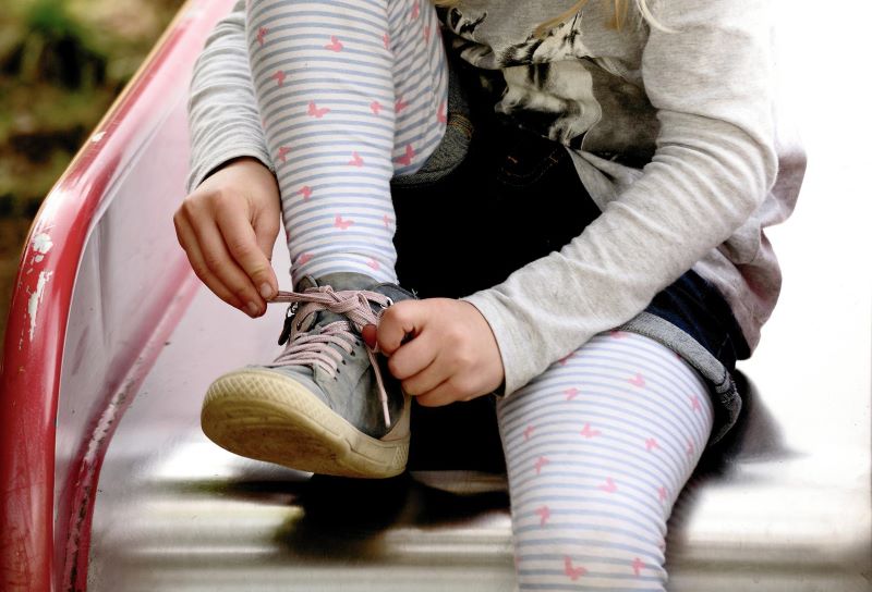 Young-girl-tying-shoe