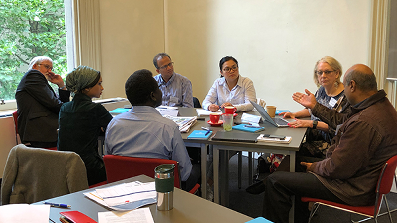 Photo of the program participants sitting at a table discussing