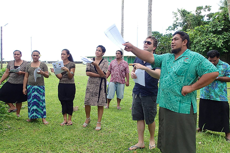 Polynesian men and women gathered on a lawn