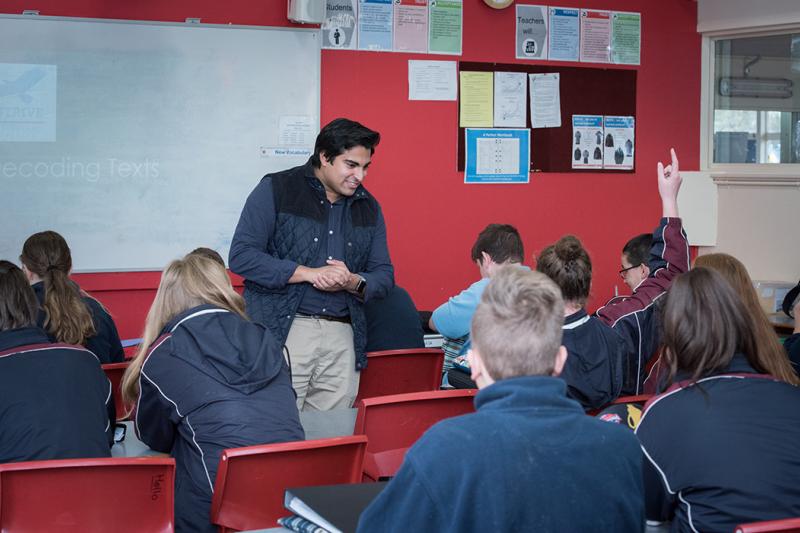 Teacher in front of a class of teens in uniform