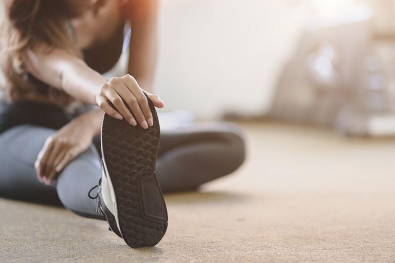 A woman stretching after playing sport.