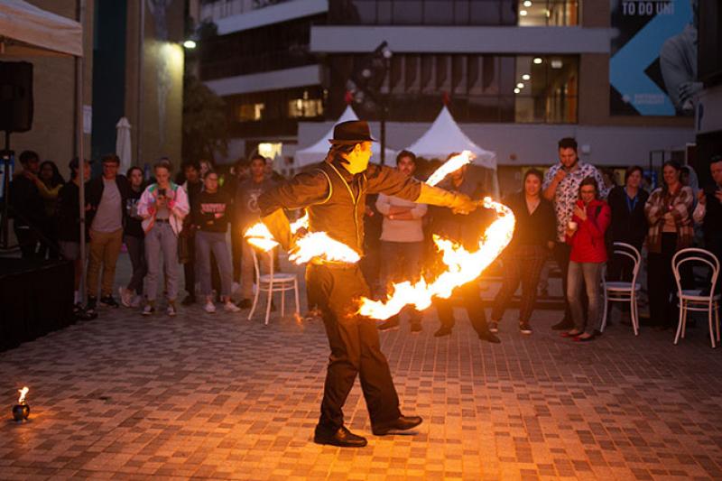 A fire twirler performs at O-Fest Block Party.