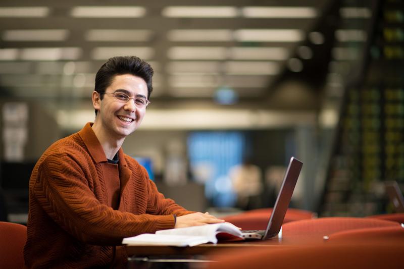 A student sits in front of a laptop at the VU Library.