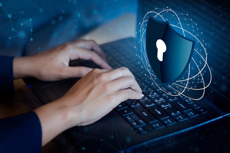 Typing on a laptop with lock graphic over the top.