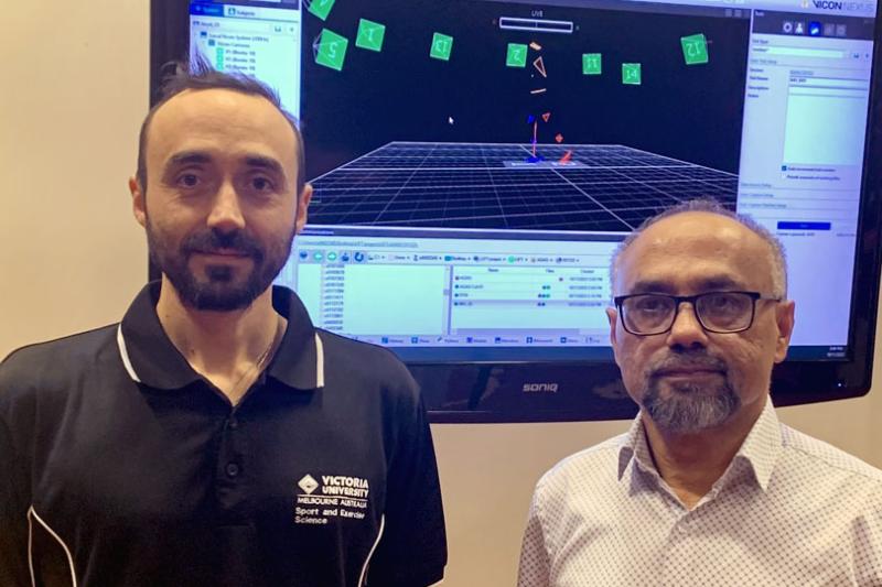 Dr Alessandro Garofolini and Professor Rezaul Begg standing in front of a screen showing biomechanics visualisations