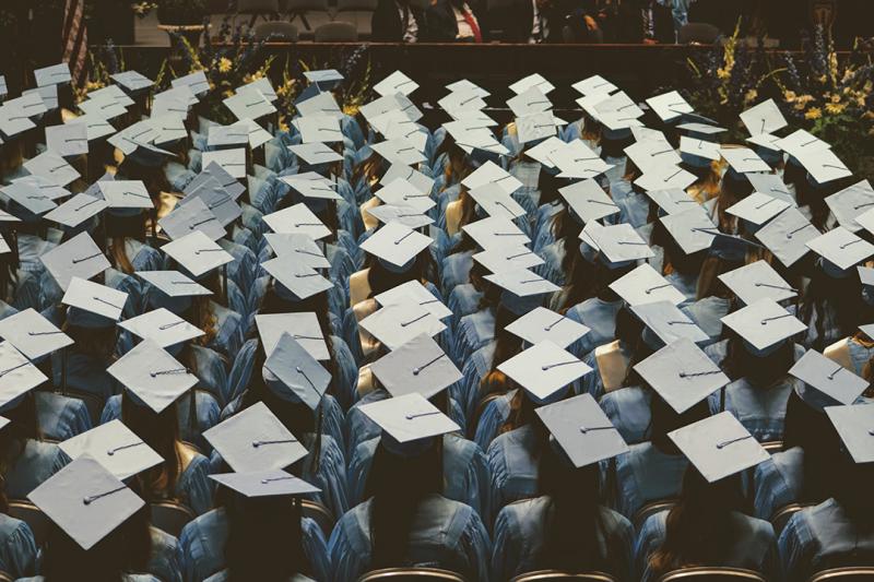 A room full of people wearing graduation caps and gowns