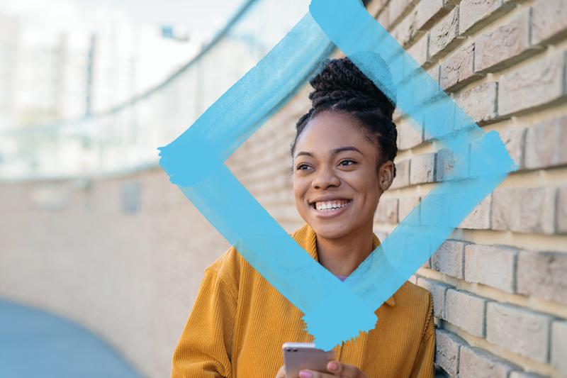 Student leaning against wall with VU blue branded diamond.