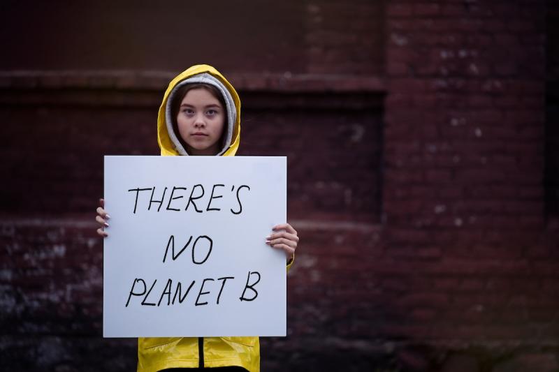 Young girl holding climate change protest sign