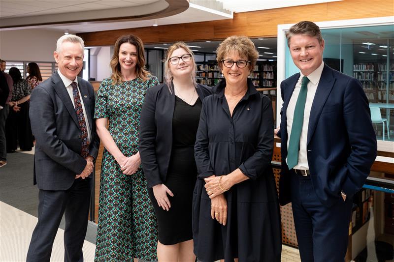 People in professional dress pose for the camera