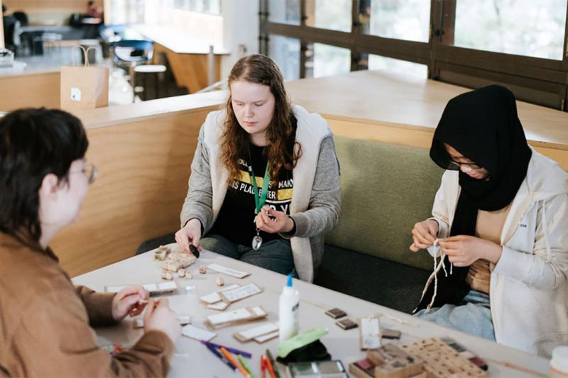 Volunteer students crafting at a table.