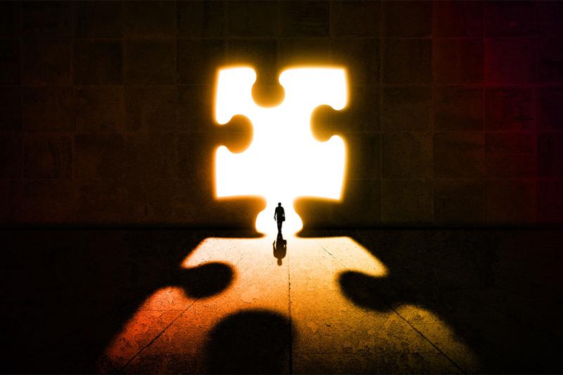 Person standing in the outline of a puzzle.