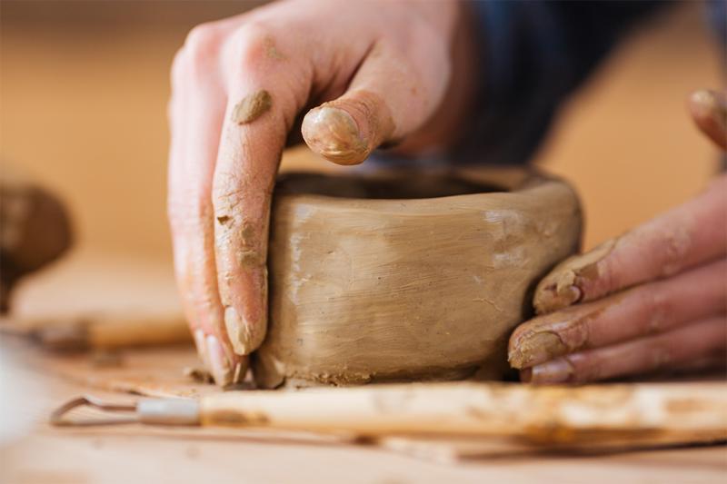 Hands making a clay bowl.